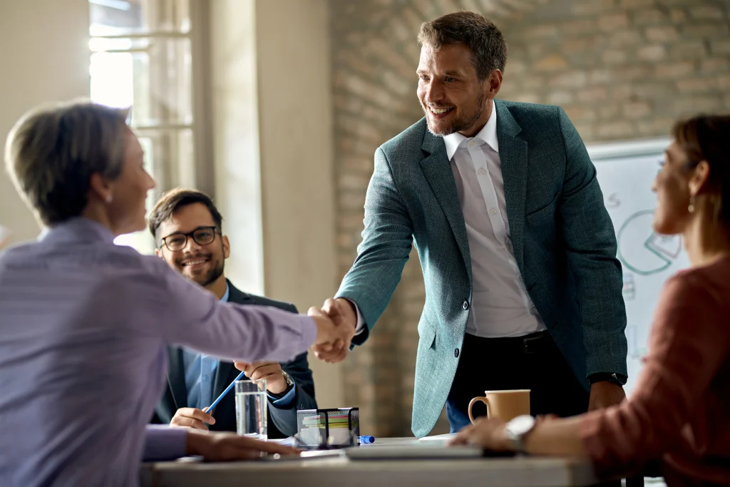 business coworkers shaking hands meeting office focus is businessman (1)