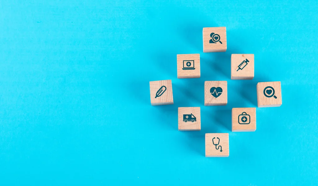 medical check up concept with wooden blocks with icons blue table flat lay