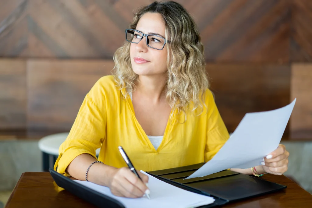 pretty female business executive working with documents table