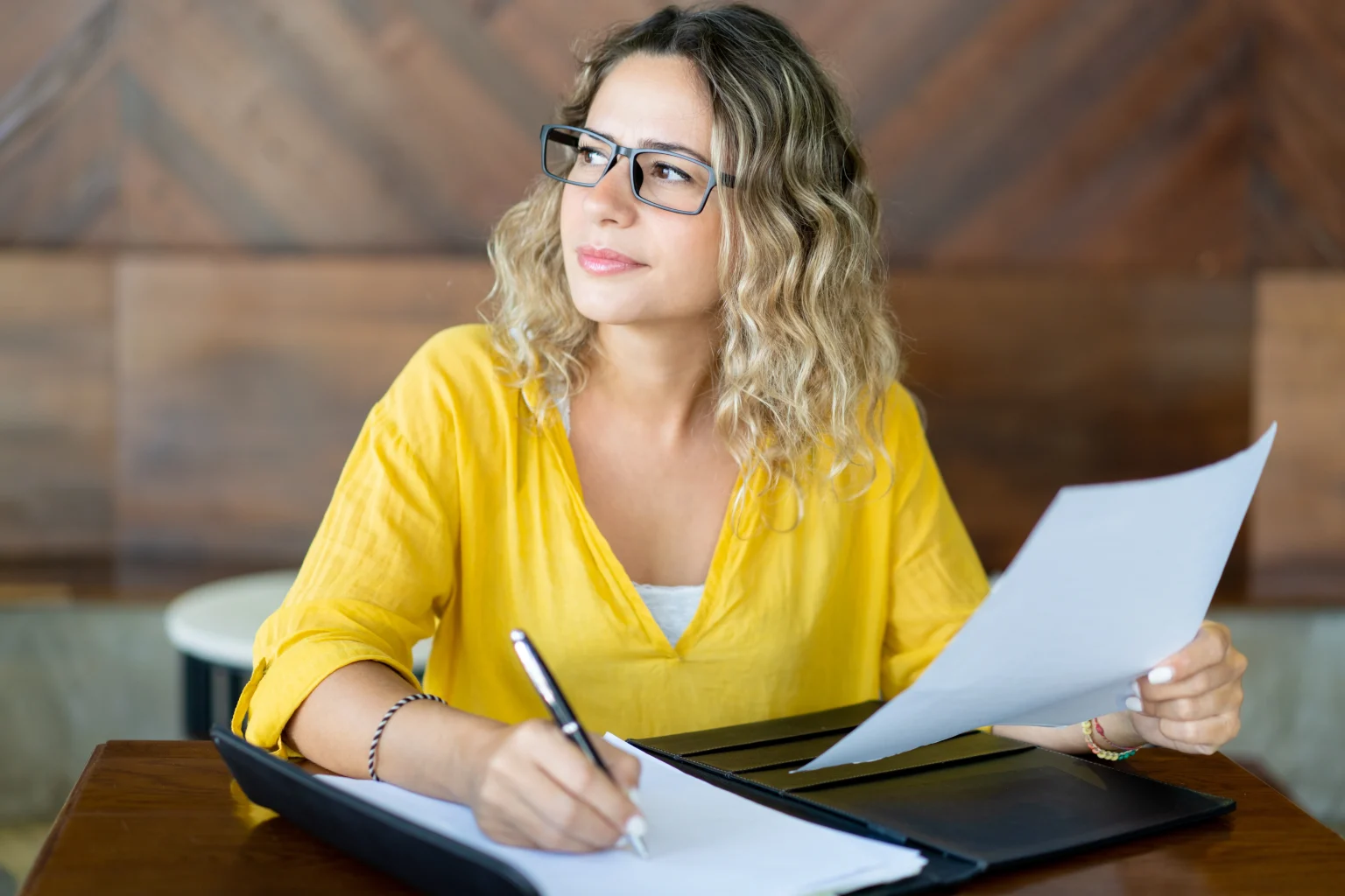 pretty female business executive working with documents table